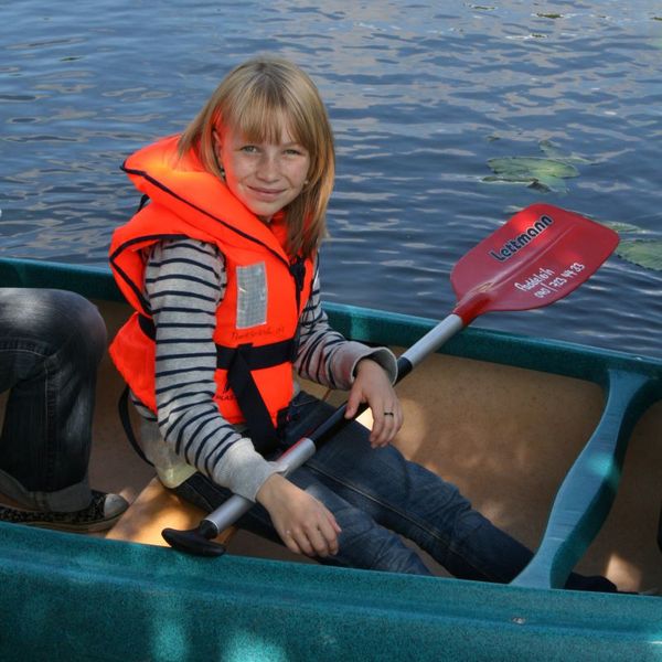 Kind mit Schwimmweste im Kanu