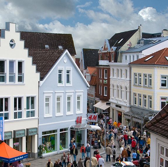 belebte Einkaufsstraße mit historischen Häusern